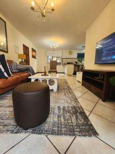 a living room with a couch and a tv at 2a - 64 No load shedding 2bed 2bath with garden in Centurion