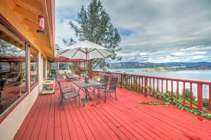 una terraza de madera con mesa, sillas y sombrilla en Spacious Kelseyville Home with Large Lakefront Deck!, en Kelseyville