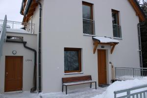 un bâtiment avec un banc dans la neige dans l'établissement U Králíka, apartmán E, à Dolní Morava