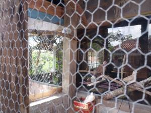 a window with a reflection of a bird in a cage at Pousada Beija flor in Extrema