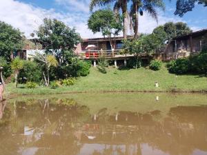 a house on a hill next to a body of water at Pousada Beija flor in Extrema