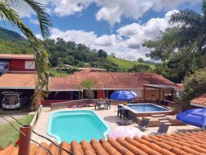 a house with a swimming pool and a patio at Pousada Beija flor in Extrema