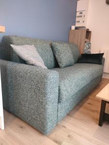 a blue couch sitting in a living room at Super studio rez de jardin avec extérieur in Lozanne