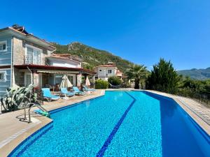 a swimming pool in front of a villa at 4 Bedroom - 3 Bathroom - 8 Person, Private Pool - Private 1000m2 Garden, DETACHED Villas, Unlimited WiFi - Free Parking in Fethiye