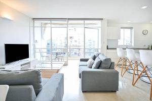 sala de estar con sofá y TV en Lovely Penthouse by HolyGuest, en Tel Aviv