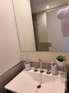 a bathroom sink with a faucet and a mirror at Suite del sol 120 in Pinamar
