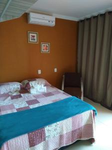 um quarto com uma cama com uma colcha em Casa em Ponta De Pedras- Encanto do Litoral! em Recife