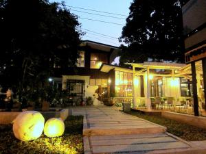 a house with two large spheres in front of it at Chiang Mai D Hostel in Chiang Mai