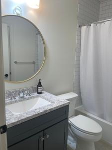 uma casa de banho com um lavatório, um WC e um espelho. em Brand New Spacious 2br - 2bth Basement em Woodbridge