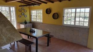 ein Esszimmer mit einem Tisch und 2 Fenstern in der Unterkunft quinta vale da corga in Murça