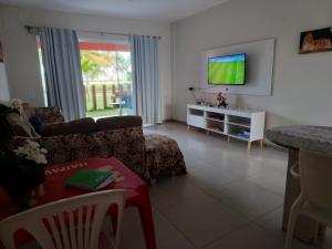 a living room with a couch and a tv at Apartamento Térreo Villa das Águas in Estância