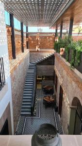a hallway with stairs in a building with plants at Hotel Boutique Rayón 50 in Morelia