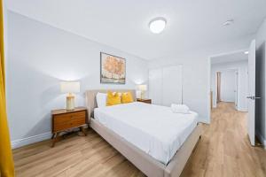 1 dormitorio blanco con 1 cama blanca y suelo de madera en Stylish & Cozy - 4Bdrm House Fast WIFI, 2.5 Bath, en Barrie