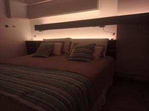 a bedroom with a large bed with pillows at Altos Caution Apart in Concepción
