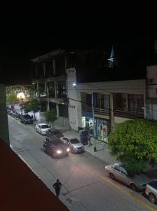 a city street at night with cars parked in a parking lot at Altos Caution Apart in Concepción