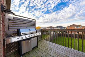 a outdoor kitchen with a grill on a deck at Stylish & Cozy - 4Bdrm House Fast WIFI, 2.5 Bath in Barrie