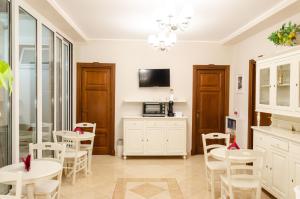 sala de estar con mesas, sillas y TV en Taormina B&B, en Taormina