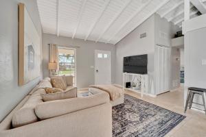 a living room with a couch and a tv at Sunny Sanctuary in Marco Island