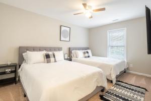a bedroom with two beds and a ceiling fan at Stunning SouthPark/Cotswold Home in Charlotte