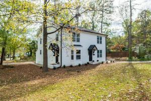 a white house with a tree in the yard at Stunning SouthPark/Cotswold Home in Charlotte