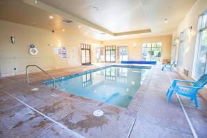 a large swimming pool with a blue chair in a room at Suite Retreat with Pool Spa Gym and Tennis Court in Hurricane