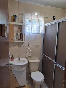 een kleine badkamer met een toilet en een wastafel bij Tia Denise Pousada in Penha