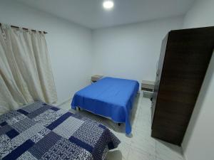 sypialnia z niebieskim łóżkiem i lustrem w obiekcie El descanso w mieście Santa Rosa
