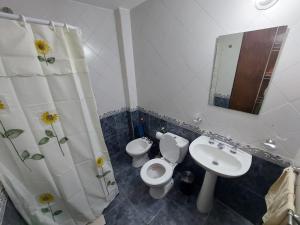 y baño con aseo, lavabo y espejo. en El descanso en Santa Rosa