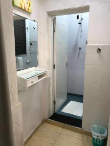 een badkamer met een douche, een wastafel en een spiegel bij Coliving Vila Mariana in Sao Paulo