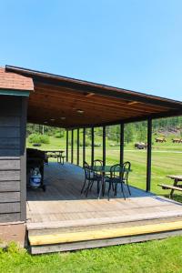 a pavilion with tables and chairs on a wooden deck at Cabin 12 at Horse Creek Resort in Rapid City +13 photos