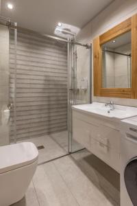 a bathroom with a toilet and a sink and a shower at Elia & Anthos Deluxe Suites in Ixia