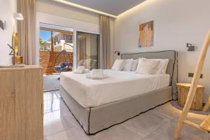a bedroom with a large bed and a balcony at Elia & Anthos Deluxe Suites in Ixia