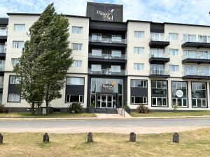 a large white building with a tree in front of it at Suite del sol 120 in Pinamar