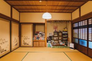 a living room with a book shelf and a ceiling at Satoyama Guest House Couture in Ayabe