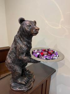 una estatua de un oso sosteniendo un plato de comida en HOTEL BOLYARI en Veliko Tŭrnovo