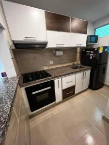 a kitchen with a stove and a refrigerator at Charming Apartment Northern Armenia in Armenia
