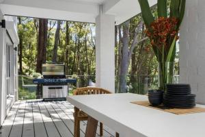 a kitchen with a table and a stove on a patio at Luxury at MacMasters Beach in Macmasters Beach