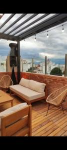 a patio with a couch and chairs on a balcony at Departamento - Salta Capital sm - Edificio Usina in Salta