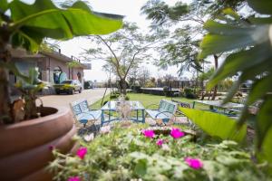 a table and chairs in a yard with pink flowers at Vanilla Twilight in Wujie