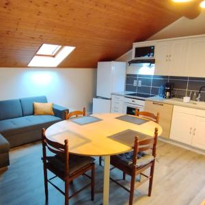kuchnia oraz stół i krzesła w pokoju w obiekcie Superbe appartement tout confort w mieście Lyaud