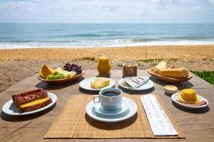 stół z jedzeniem i napojami na plaży w obiekcie Tamikuã Mar Pousada w mieście Caraíva