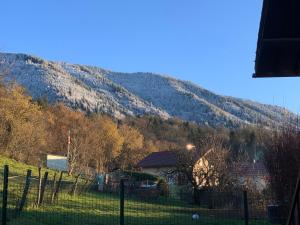 ogrodzenie przed wzgórzem z domem w obiekcie Superbe appartement tout confort w mieście Lyaud