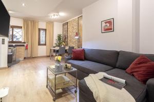 ein Wohnzimmer mit einem Sofa und einer Küche in der Unterkunft -MalagaSunApts-Urban&Central in Málaga