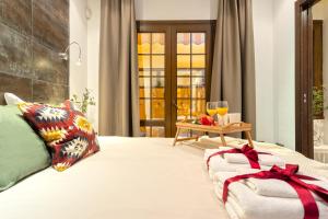 Schlafzimmer mit einem Bett und einem Tisch mit zwei Gläsern Wein in der Unterkunft -MalagaSunApts-Urban&Central in Málaga