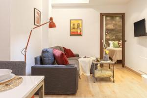 ein Wohnzimmer mit einem Sofa und einem Tisch in der Unterkunft -MalagaSunApts-Urban&Central in Málaga