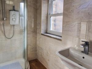 a bathroom with a shower and a sink at The Barn in Blagdon