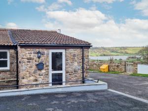 a stone cottage with a view of the water at The Barn in Blagdon