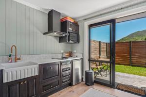uma cozinha com um lavatório e uma grande janela em Stagford Retreat Apartment - Taupo em Taupo