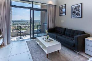 a living room with a couch and a table at Menlyn Maine - The Trilogy Apartment 1111 in Pretoria