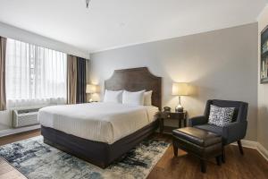 a hotel room with a bed and a chair at St Charles Inn, Superior Hotel in New Orleans